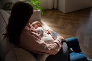 Madre con depresión posparto sosteniendo con cariño a su bebé recién nacido