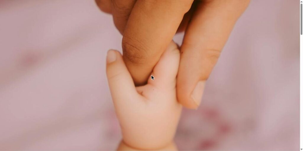 Newborn baby's hand gripping a parent's finger, symbolizing support through the fears of motherhood and fatherhood