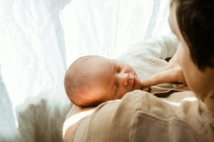 Parent holding a sleeping baby, representing emotional preparation for birth